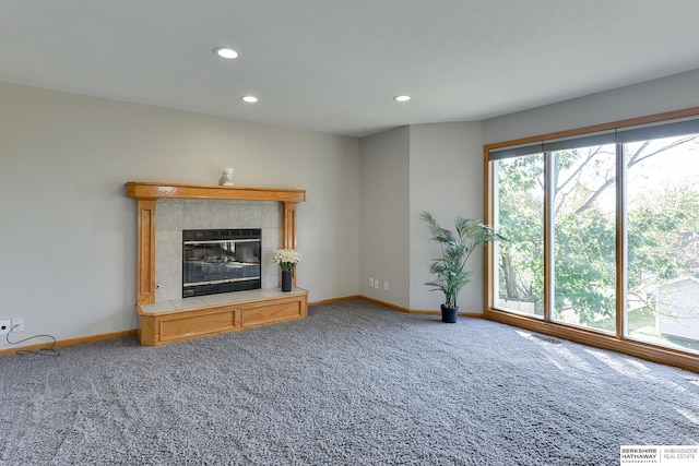 unfurnished living room with carpet floors and a tiled fireplace