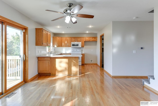 kitchen with ceiling fan, tasteful backsplash, kitchen peninsula, light hardwood / wood-style floors, and white appliances