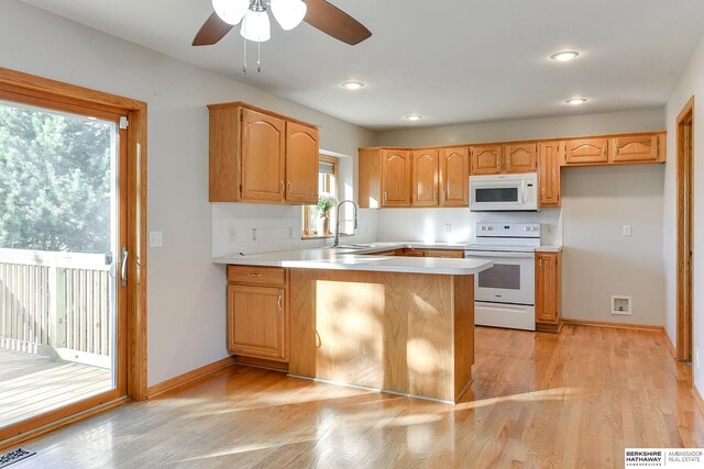 kitchen with white appliances, sink, ceiling fan, light wood-type flooring, and tasteful backsplash