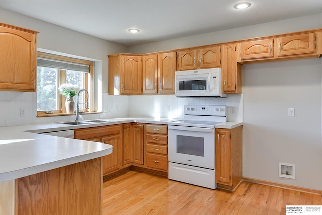 kitchen featuring backsplash, light wood-type flooring, white appliances, and sink