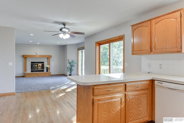 kitchen with ceiling fan, tasteful backsplash, light hardwood / wood-style flooring, kitchen peninsula, and white dishwasher