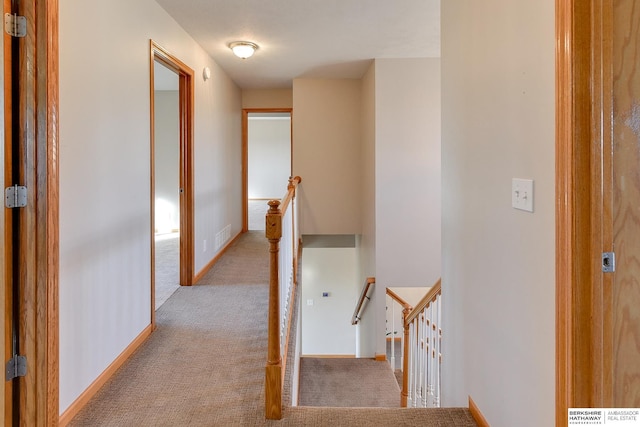 corridor featuring light colored carpet