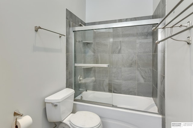 bathroom featuring bath / shower combo with glass door and toilet