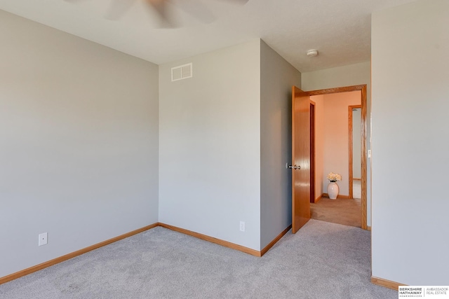 empty room with ceiling fan and light colored carpet