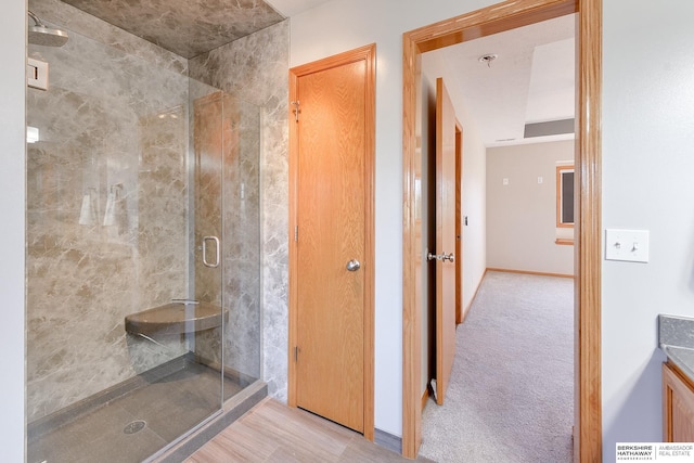 bathroom with a shower with door, vanity, and wood-type flooring