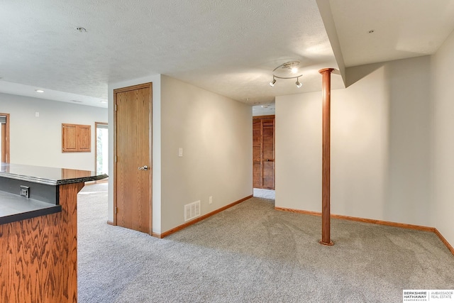 interior space with a textured ceiling and light carpet