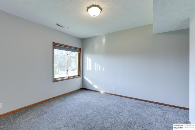 carpeted spare room with a textured ceiling