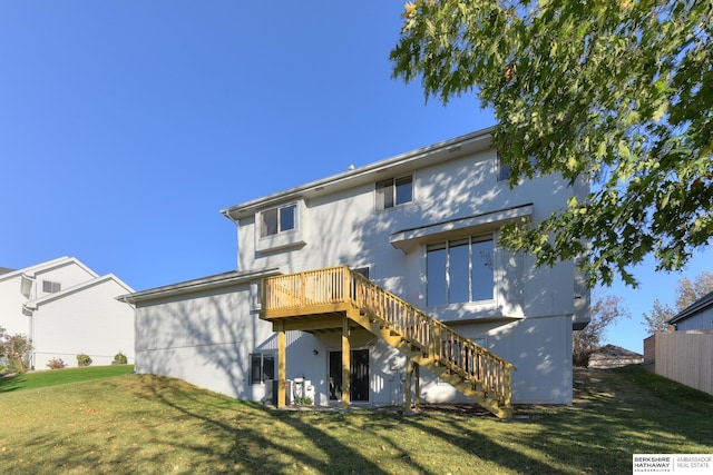 rear view of property featuring a wooden deck and a yard