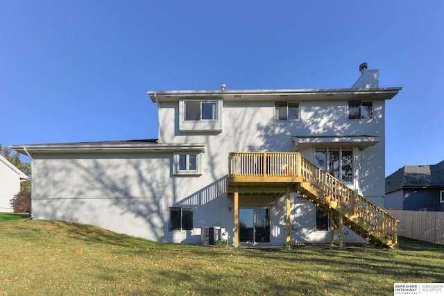 rear view of property featuring a yard, central AC unit, and a wooden deck