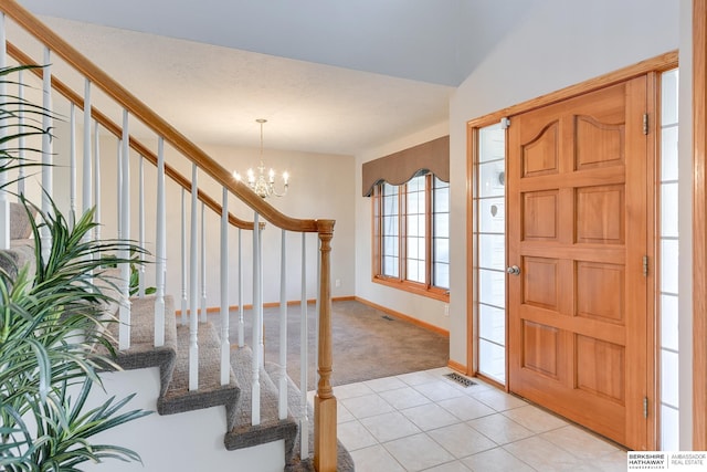 carpeted entryway featuring a chandelier and vaulted ceiling