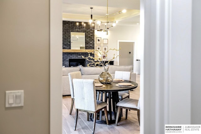 dining area with hardwood / wood-style floors, a fireplace, and a chandelier