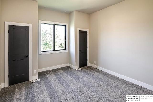 unfurnished bedroom with dark colored carpet