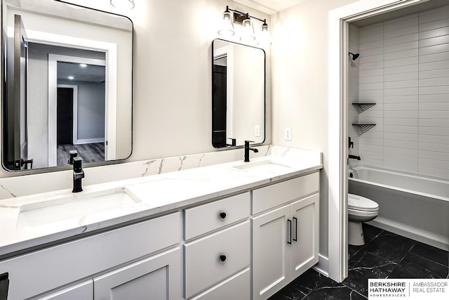 full bathroom with vanity, tiled shower / bath combo, and toilet