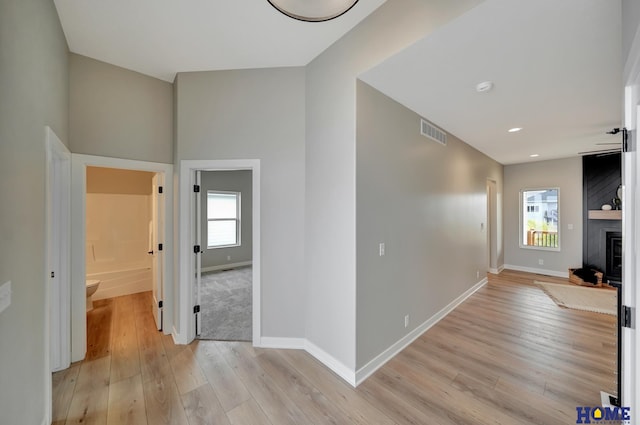 hallway featuring a healthy amount of sunlight and light wood-type flooring