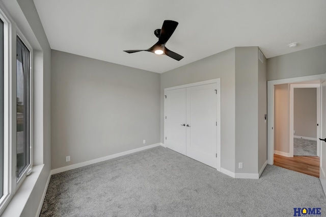 unfurnished bedroom featuring ceiling fan, a closet, and light carpet