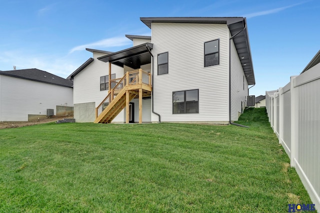 back of property with a lawn and a wooden deck