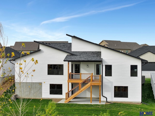 rear view of property with a yard, a deck, and a patio area