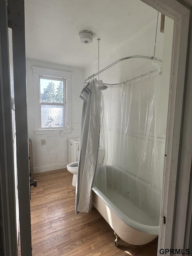 1424 4th Ave, Scottsbluff, NE 69361 - bathroom featuring wood-type flooring, toilet, and shower / bath combination with curtain