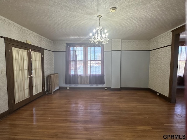 1424 4th Ave, Scottsbluff, NE 69361 - unfurnished dining area with a chandelier, french doors, dark hardwood / wood-style floors, and radiator