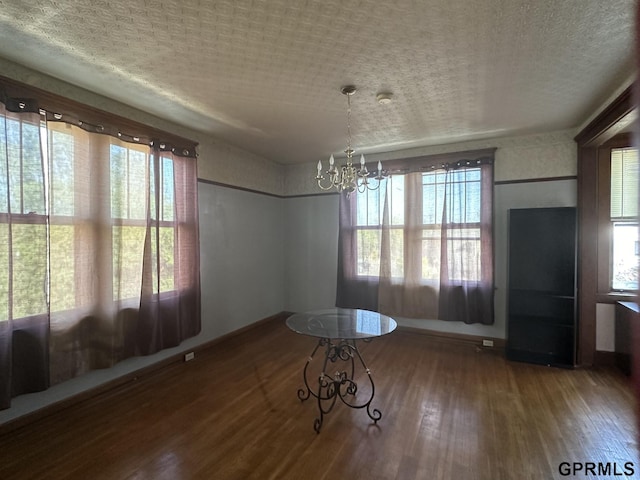 1424 4th Ave, Scottsbluff, NE 69361 - unfurnished dining area featuring wood-type flooring and an inviting chandelier