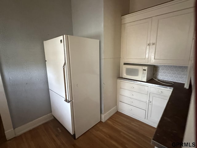 1424 4th Ave, Scottsbluff, NE 69361 - kitchen with tasteful backsplash, dark hardwood / wood-style flooring, white cabinets, and white appliances