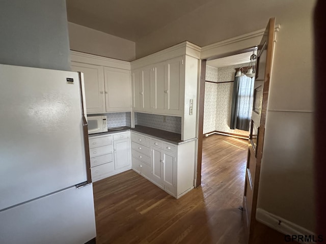 1424 4th Ave, Scottsbluff, NE 69361 - kitchen featuring white cabinets, dark hardwood / wood-style floors, white appliances, and tasteful backsplash