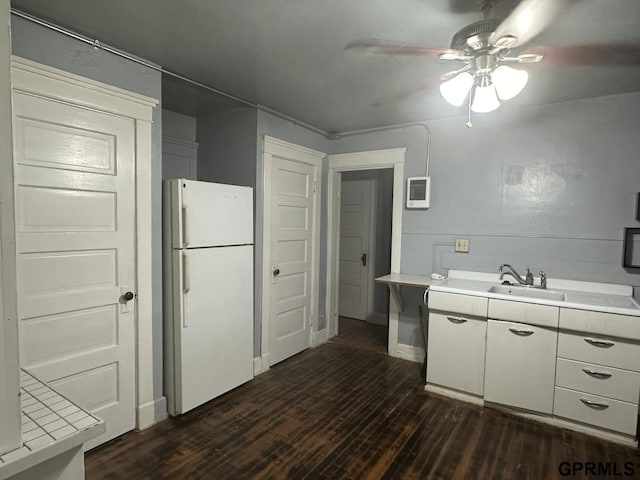1424 4th Ave, Scottsbluff, NE 69361 - kitchen featuring white cabinetry, ceiling fan, sink, dark wood-type flooring, and white fridge