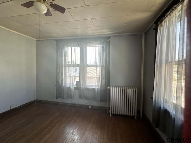 1424 4th Ave, Scottsbluff, NE 69361 - empty room featuring dark hardwood / wood-style floors, radiator, ornamental molding, and ceiling fan