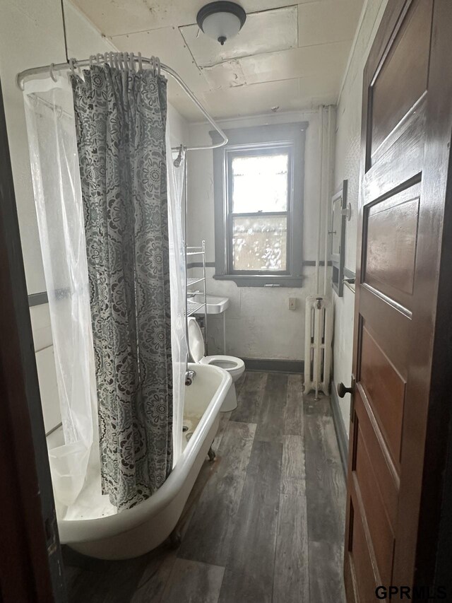 1424 4th Ave, Scottsbluff, NE 69361 - bathroom featuring toilet, radiator heating unit, hardwood / wood-style floors, and a shower with shower curtain