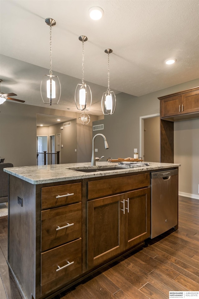 kitchen featuring a center island with sink, stainless steel dishwasher, hanging light fixtures, and dark wood-type flooring