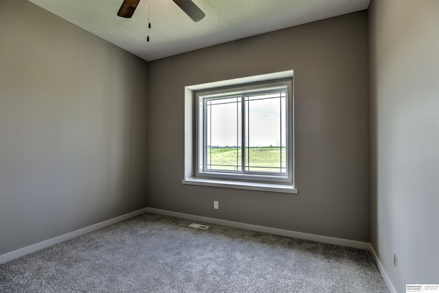 carpeted empty room with ceiling fan and a textured ceiling