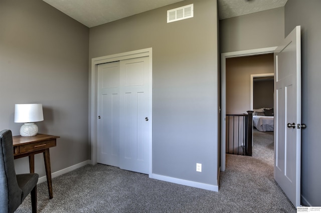 bedroom featuring carpet, a textured ceiling, and a closet