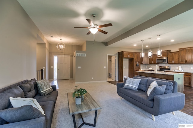 living room featuring ceiling fan with notable chandelier and carpet floors