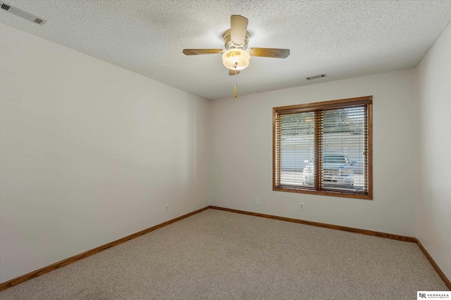 carpeted spare room with ceiling fan and a textured ceiling