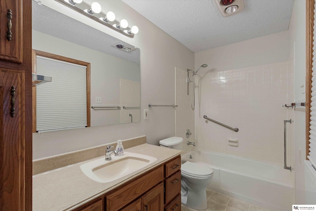 full bathroom featuring vanity, tile patterned flooring, tiled shower / bath combo, toilet, and a textured ceiling