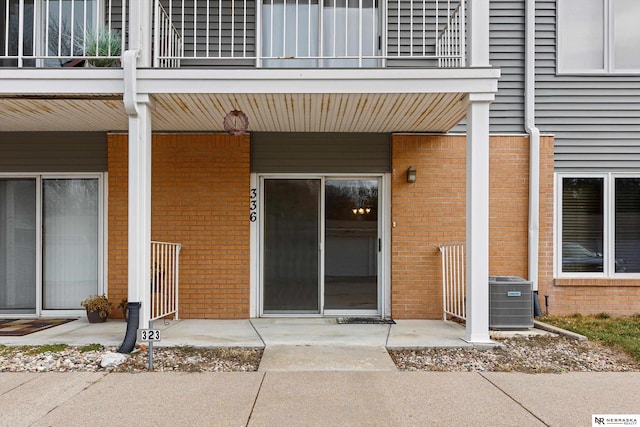 property entrance with a balcony and central air condition unit