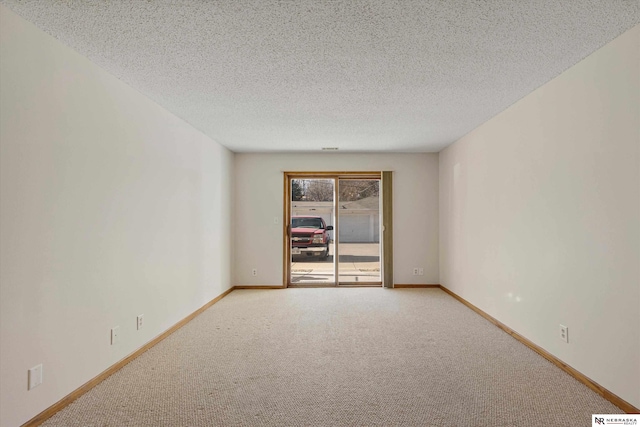 carpeted spare room with a textured ceiling