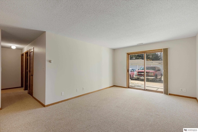 unfurnished room featuring carpet flooring and a textured ceiling