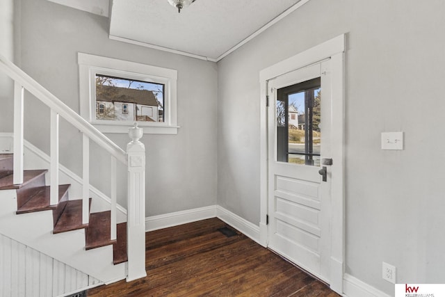 entryway with a textured ceiling, dark hardwood / wood-style floors, and ornamental molding