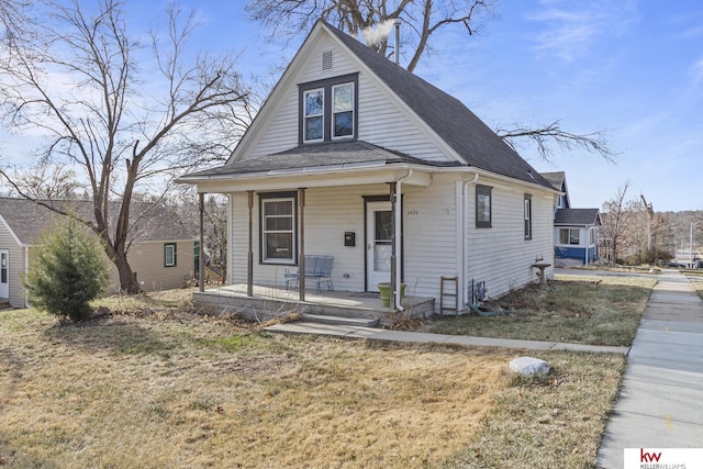 bungalow-style home featuring covered porch and a front yard