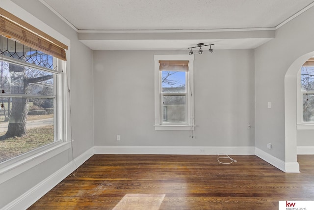 unfurnished dining area featuring ornamental molding, dark wood-type flooring, and a healthy amount of sunlight