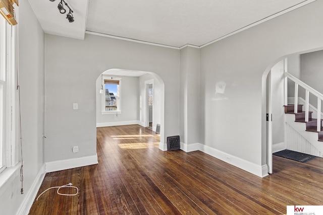 interior space featuring ornamental molding and dark wood-type flooring