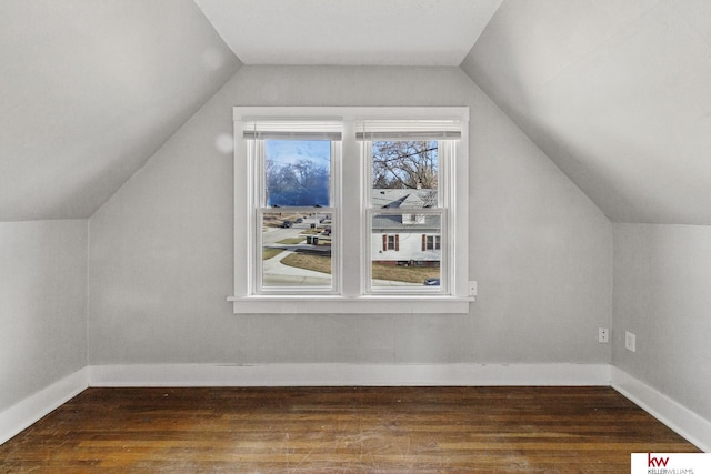 additional living space with vaulted ceiling and dark wood-type flooring