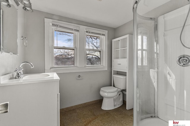 bathroom featuring toilet, vanity, and walk in shower