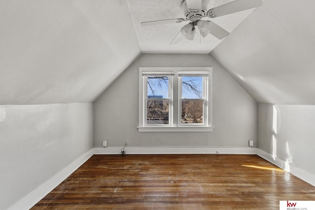 additional living space featuring dark hardwood / wood-style flooring, vaulted ceiling, and ceiling fan