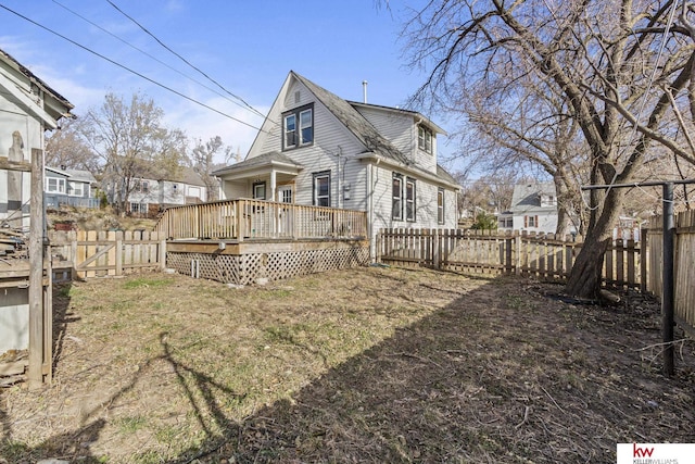 rear view of house with a lawn and a wooden deck