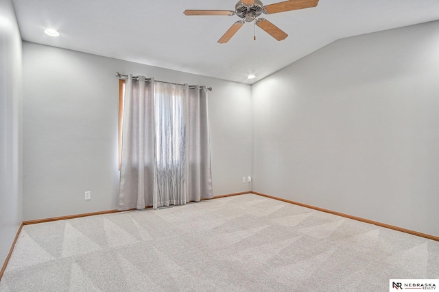 empty room with carpet flooring, vaulted ceiling, and ceiling fan