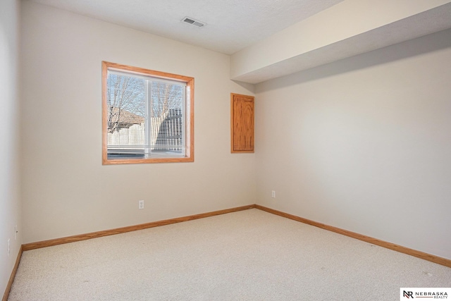 carpeted spare room with a textured ceiling