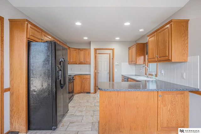 kitchen with tasteful backsplash, kitchen peninsula, sink, and black appliances