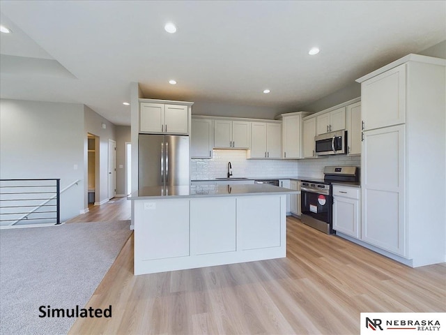 kitchen with sink, light wood-type flooring, white cabinetry, and stainless steel appliances